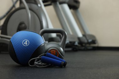 Mavi ilaç topu, kettlebell ve atlama halatı spor salonunda, mesaj atmak için yer
