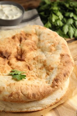 Ahşap masada nefis ev yapımı pide ekmeği, yakın plan.