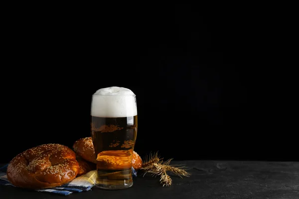 Lekkere Krakelingen Glas Bier Tarwespikes Zwarte Tafel Tegen Donkere Achtergrond — Stockfoto