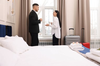 Otel odasının penceresinin yanında kahve bardakları olan iş adamları.