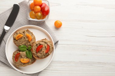 Lezzetli ezmeli taze ekmek dilimleri ve beyaz ahşap masadaki domatesler. Metin için boşluk