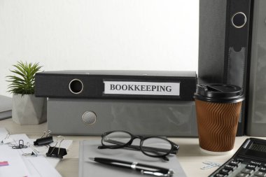 Masasında klasörler ve belgeler olan muhasebecinin çalışma yeri