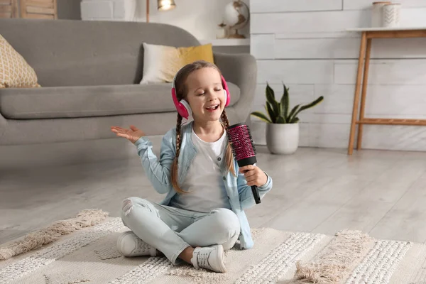 Χαριτωμένο Κοριτσάκι Ακουστικά Και Βούρτσα Τραγουδάει Στο Σπίτι — Φωτογραφία Αρχείου