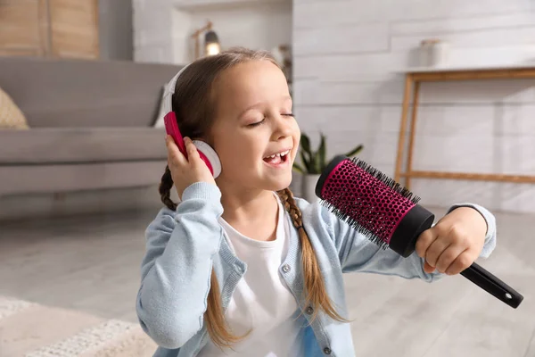 Evde Saç Fırçasıyla Şarkı Söyleyen Kulaklıklı Şirin Bir Kız — Stok fotoğraf