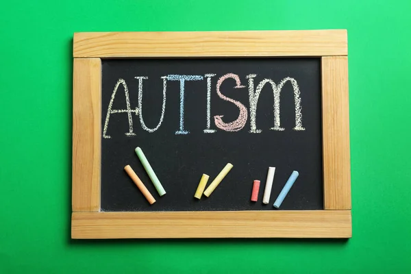 Schoolbord Met Woord Autisme Kleurrijke Krijtjes Groene Achtergrond Bovenaanzicht — Stockfoto