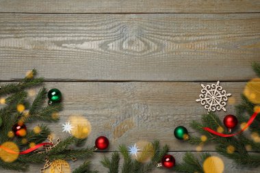 Noel tebrik kartı ve mesaj için yer var. Köknar ağacı dallarının düz kompozisyonu ve ahşap arka planda şenlikli dekor.