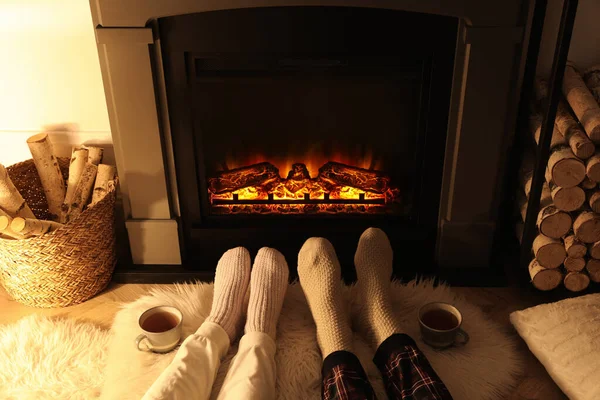 自宅の暖炉の近くの編んだ靴下のカップル 足の閉鎖 — ストック写真