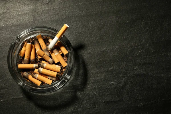 Skleněný Popelník Cigaretovými Pahýly Tmavě Šedém Stole Horní Pohled Mezera — Stock fotografie