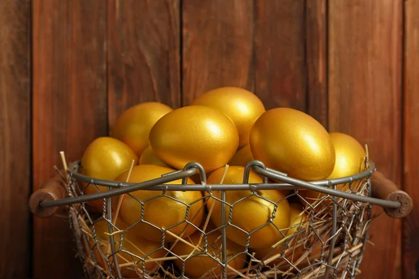 Glanzende Gouden Eieren Metalen Mandje Houten Ondergrond — Stockfoto
