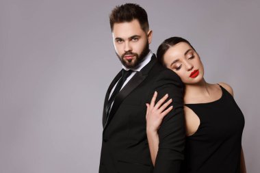Gri arka planda seksi bayan olan yakışıklı sakallı adam. Metin için boşluk