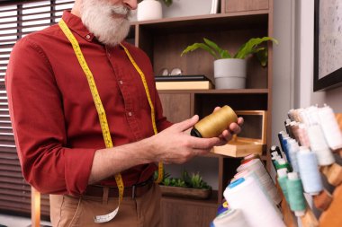 Profesyonel terzi atölyenin yanında iplik seçiyor, yakın plan