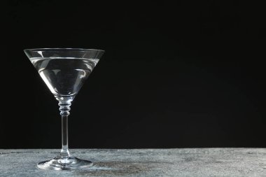 Gri masada koyu arkaplanda martini kokteyli. Metin için boşluk