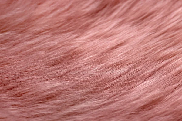 Pink faux fur as background, top view