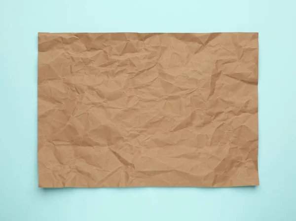 Sheet Crumpled Brown Paper Light Blue Background Top View — Stock Photo, Image