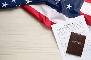 Amerikan bayrağı, vize başvuru formu ve beyaz ahşap masa üzerinde pasaport. Metin için boşluk