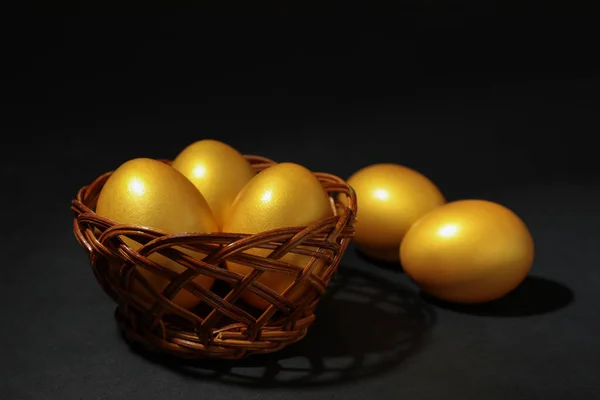 Glanzende Gouden Eieren Rieten Schaal Zwarte Achtergrond — Stockfoto