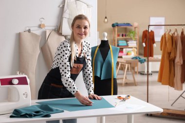 Atölyede terzi kumaşı tebeşirle işaretliyor