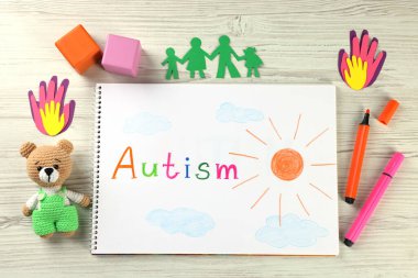 Düz dizüstü bilgisayar kompozisyonu Otizm ve oyuncaklar beyaz ahşap masa üzerinde