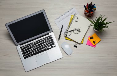 Modern dizüstü bilgisayar, gözlükler ve ofis kağıtları beyaz ahşap masa, düz yatak. Uzaklık öğrenimi