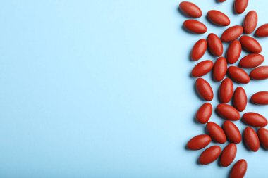 Açık mavi arka planda kırmızı haplar, düz yerde uzanıyordu. Anemi tedavisi