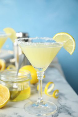 Lezzetli arı dizleri kokteyli ve beyaz mermer masa üzerindeki malzemeler açık mavi arka planda