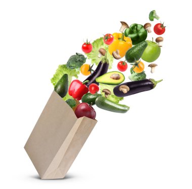 Beyaz arka planda farklı meyve ve sebzelerle dolu kese kağıdı.