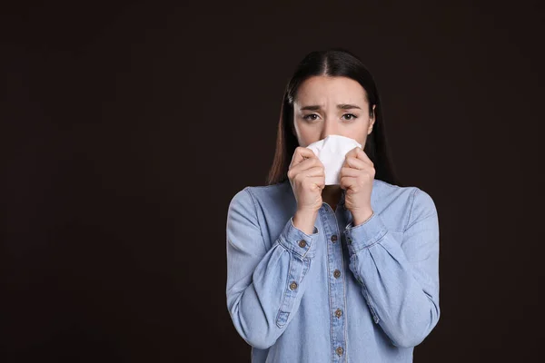 暗い背景に組織で鼻を吹いて若い女性 テキストのためのスペース 風邪の症状 — ストック写真