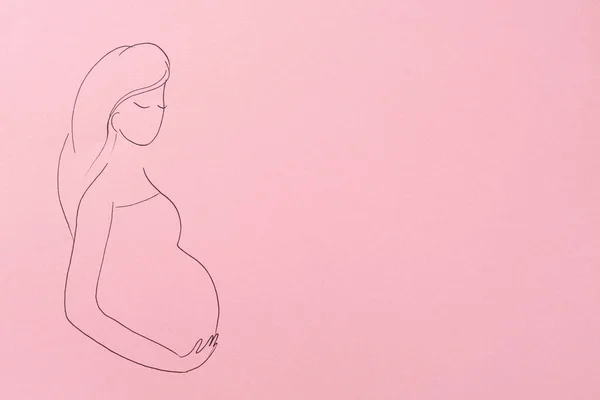 Pregnant woman figure drawn on pink background, top view with space for text. Surrogacy concept