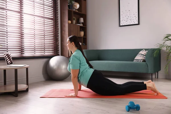 在家做瑜伽垫运动的超重妇女 — 图库照片
