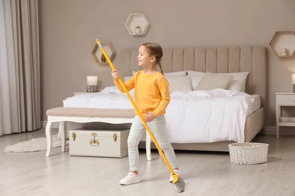 Yatak Odasını Temizlerken Süpürgeyle Şarkı Söyleyen Tatlı Küçük Kız — Stok fotoğraf