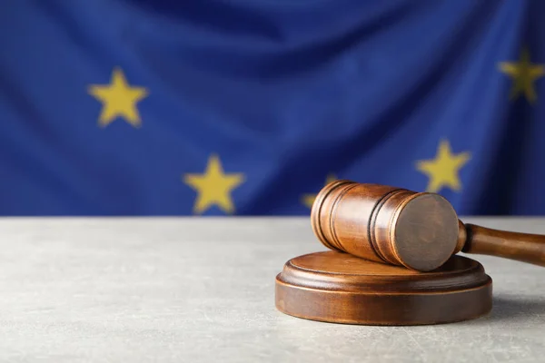 木制法官的木槌在灰色桌子上与欧盟旗帜相对立 案文的篇幅 — 图库照片