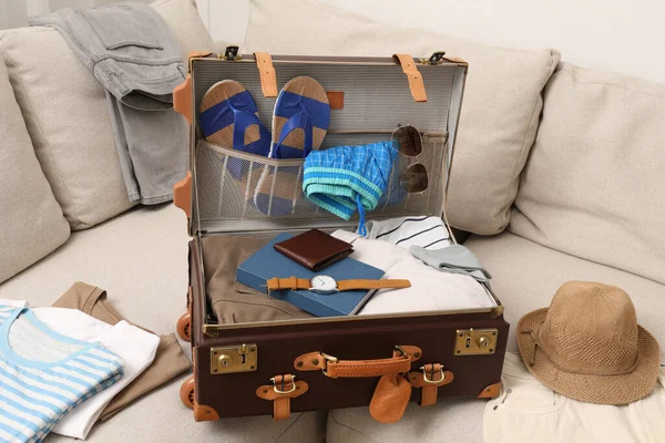 Farklı Erkek Kıyafetleri Aksesuarlarıyla Dolu Bavulu Kanepenin Üzerinde — Stok fotoğraf