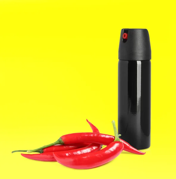 Flasche Pfefferspray Und Rote Chilischoten Auf Gelbem Hintergrund — Stockfoto