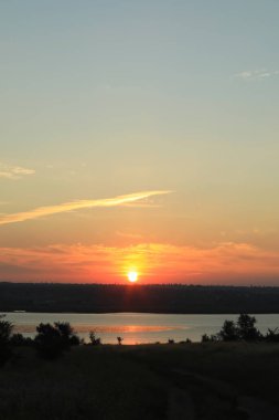 Güneşin doğuşunda nehrin üzerinde bulutlu güzel bir gökyüzü manzarası