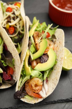 Siyah masada karides ve avokado ile nefis tacolar, yakın plan.