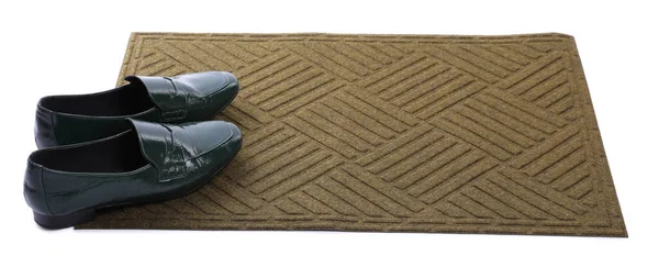 New clean door mat with shoes on white background