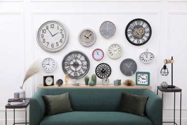 Farklı saat koleksiyonu ve şık bir odada rahat bir kanepe. İç tasarım