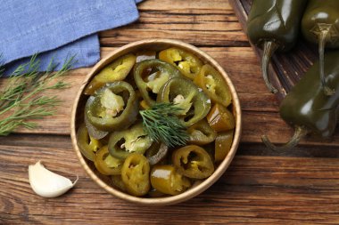 Düz kompozisyon, ahşap masada turşulu yeşil biberli.