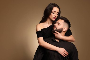 Açık kahverengi arka planda seksi bayan olan yakışıklı sakallı adam. Metin için boşluk