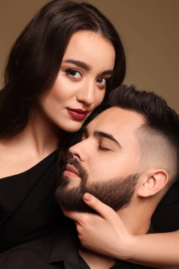Kahverengi arka planda seksi bayan olan yakışıklı sakallı adam, yakın plan.