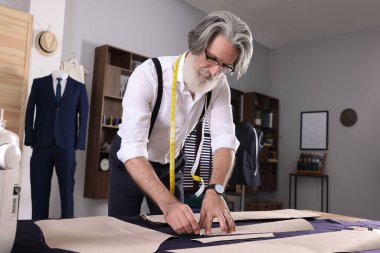 Profesyonel terzi dikiş deseni atölyedeki masada tebeşirle dikilmiş.