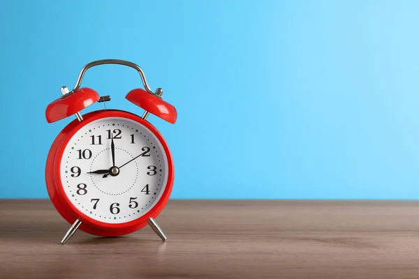 Reloj Despertador Rojo Sobre Mesa Madera Sobre Fondo Azul Claro —  Fotos de Stock