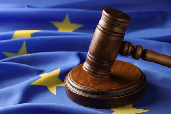 Wooden judge's gavel on flag of European Union, closeup
