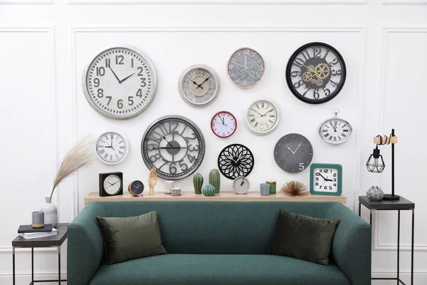 Farklı saat koleksiyonu ve şık bir odada rahat bir kanepe. İç tasarım