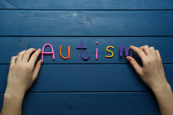 Vrouw Maakt Woord Autisme Met Kleurrijke Plasticine Blauwe Houten Tafel — Stockfoto