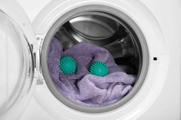 洗濯機のドラムに緑のドライヤーボールとタオル — ストック写真