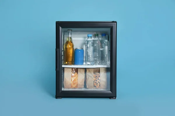 Mini bar filled with food and drinks on turquoise background