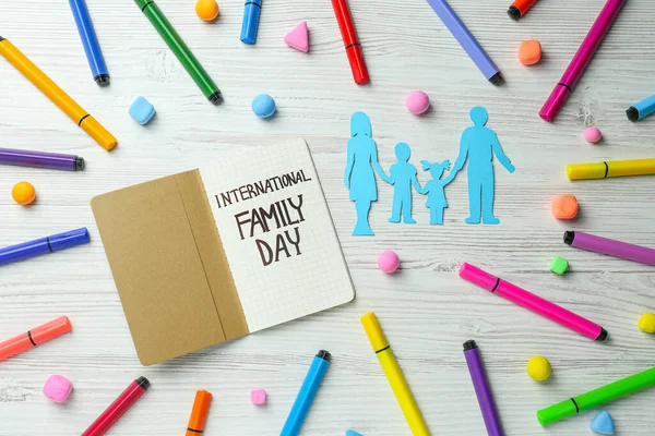 祝家庭日快乐 在白色木制桌子上的笔记本旁边 平铺着父母和孩子们的作文 — 图库照片