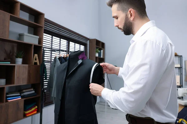 Atölyede çalışan mezuralı bir terzi.