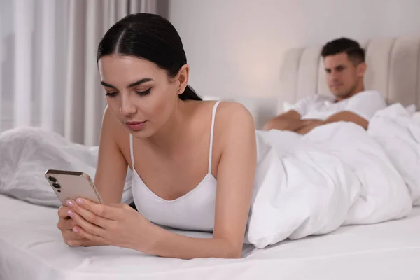 上网成瘾 拿着智能手机的女人在卧室里无视男朋友 — 图库照片